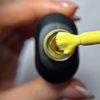 Cuccio Sunlit Smirk gel nail polish brush showing Sun Yellow highly pigmented colour
