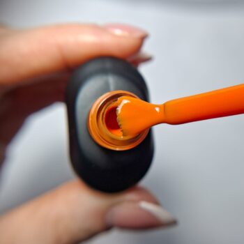 Cuccio Warm Whim gel nail polish brush showing sunset orange highly pigmented colour